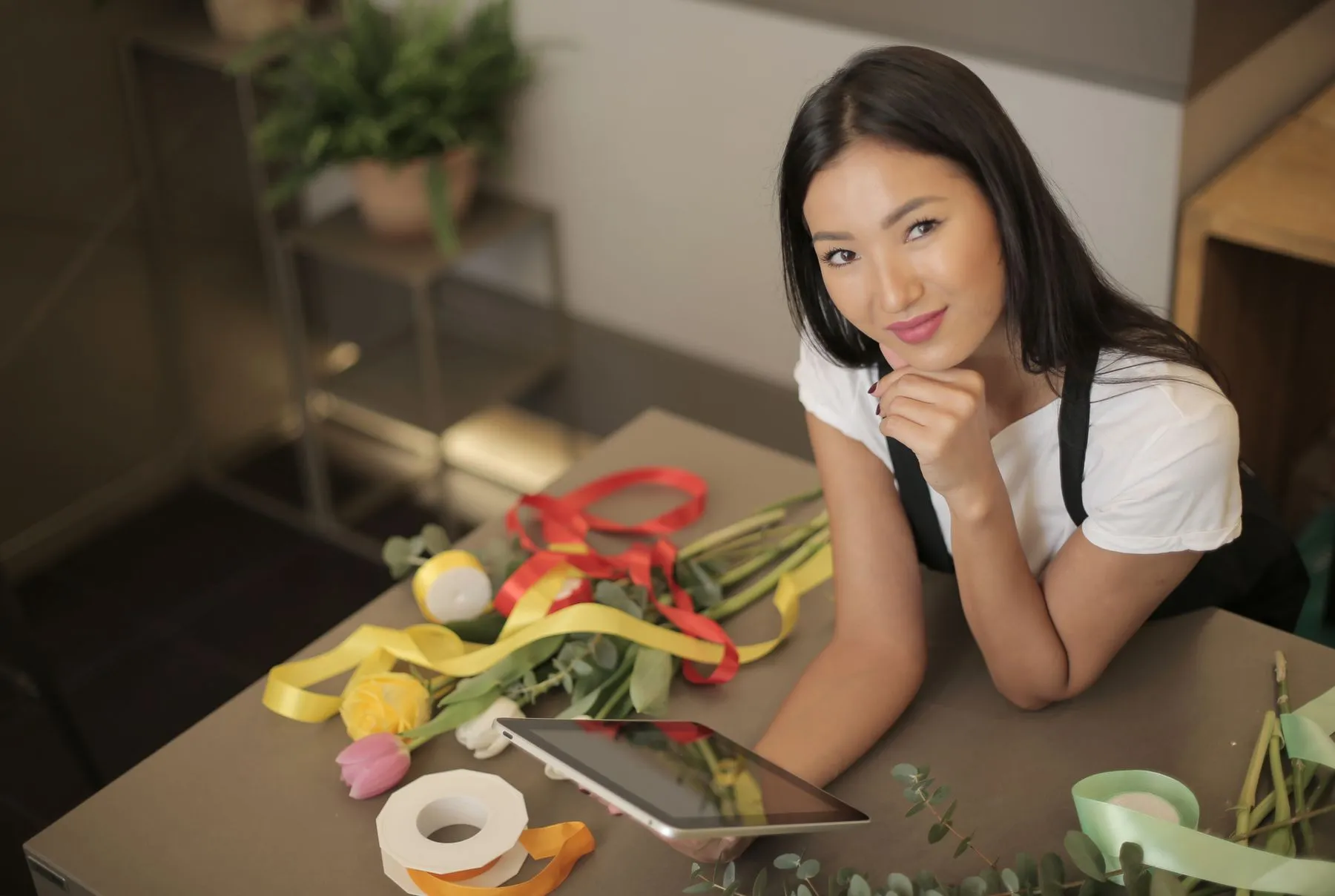 Florist holding a tablet at her worktable