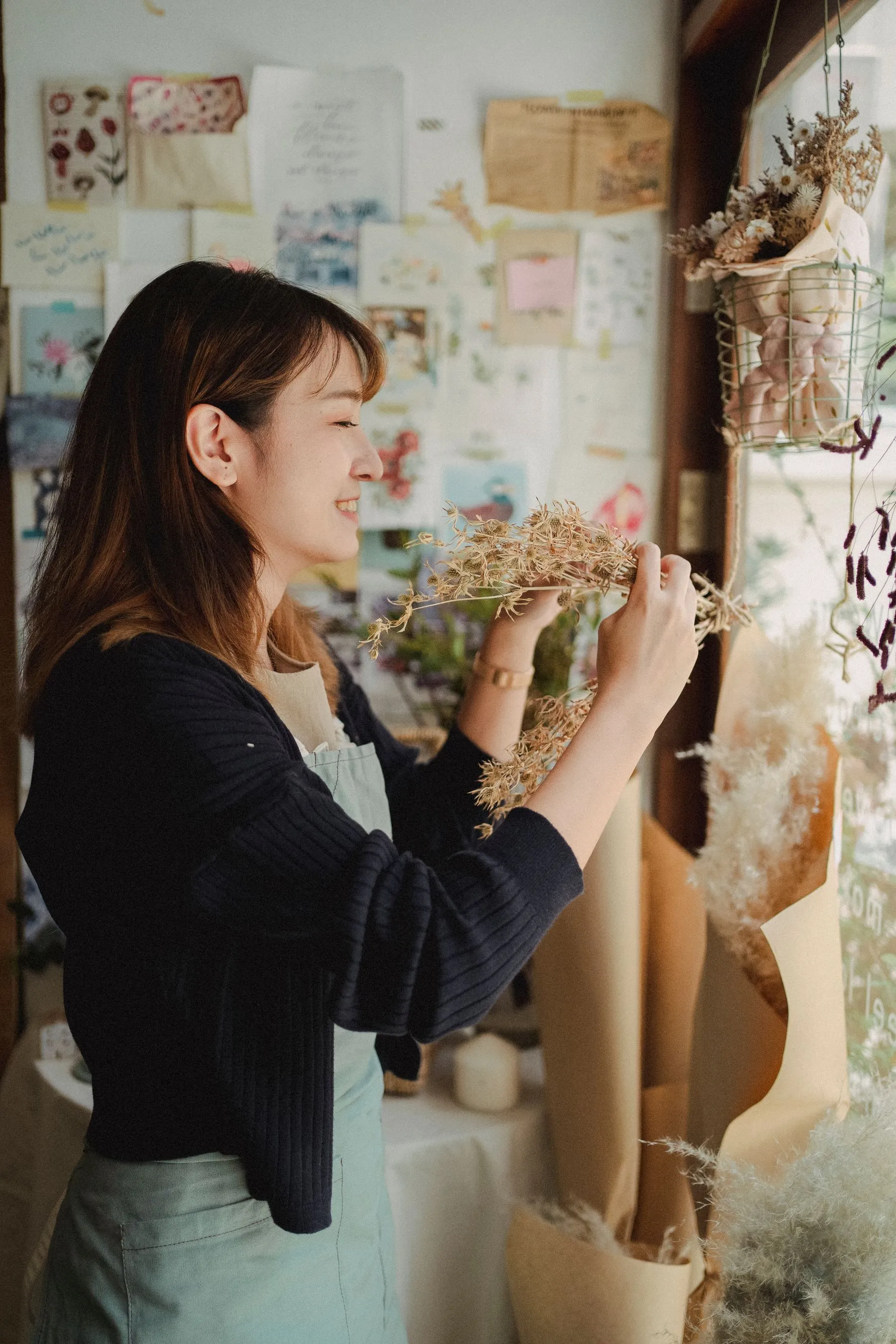 Florist arranging dried flowers in her shop