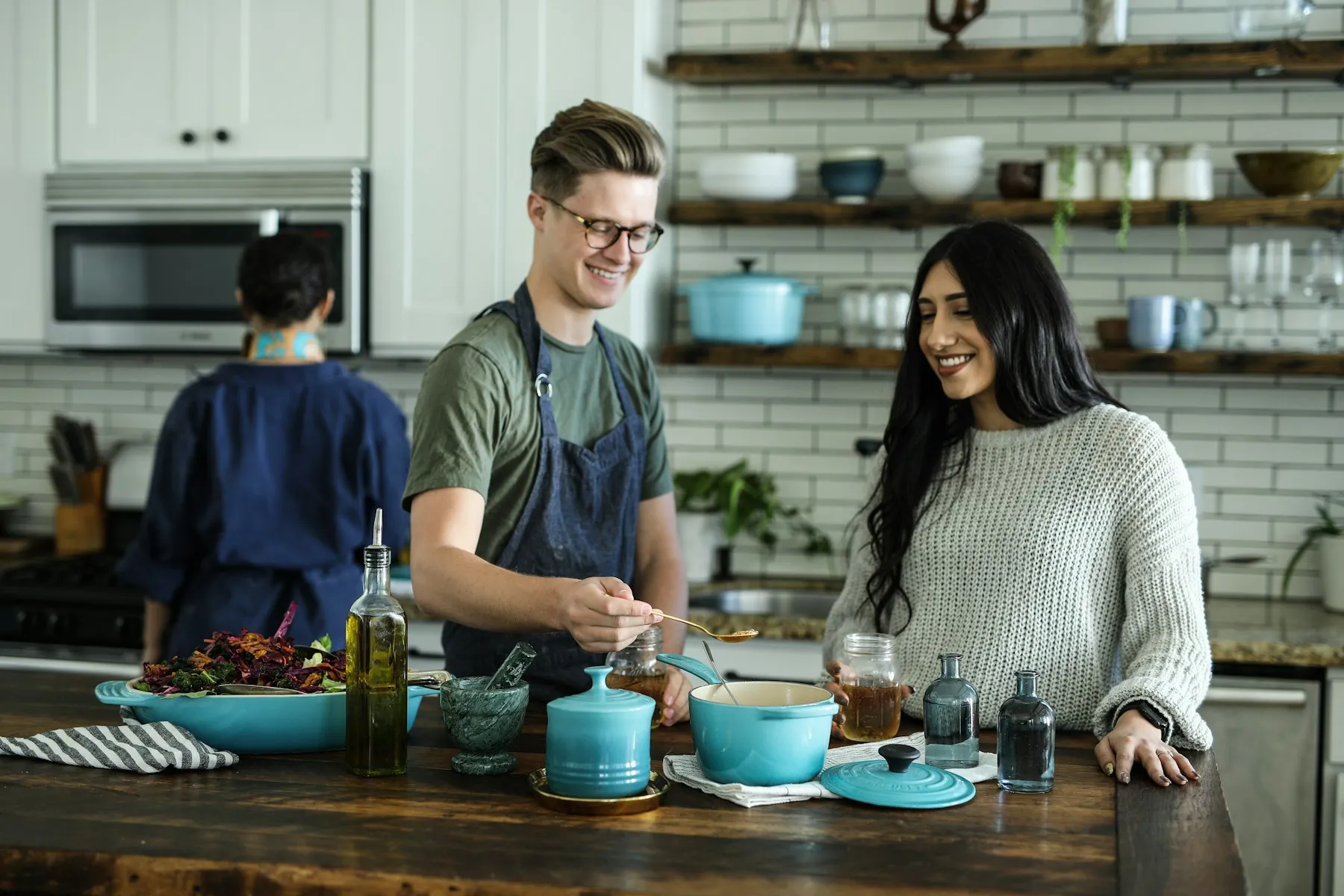 Independent kitchen team preparing food together at a wooden prep counter